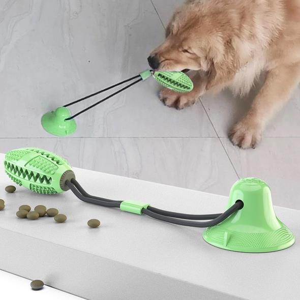 Dog playing with a green WagBrush suction-cup toy on a smooth floor